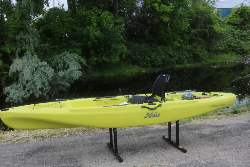 The Image of Yellow 2025 Hobie Mirage Passport 12.0 R kayak displayed outdoors near a river. - 1