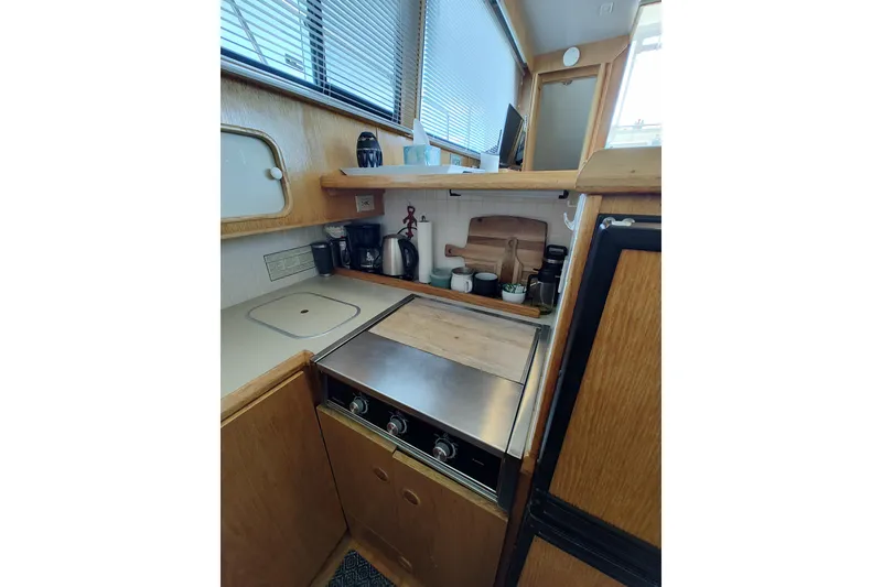 Slide: The Image of 1989 Chris-Craft 372 Catalina yacht kitchen with stove, cabinets, and appliances. - 11