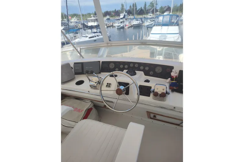 Slide: The Image of 1989 Chris-Craft 372 Catalina helm with steering wheel and control panel at marina. - 4