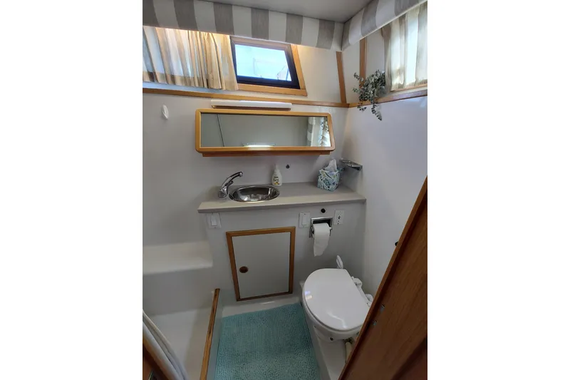 Slide: The Image of 1989 Chris-Craft 372 Catalina bathroom with sink, toilet, mirror, and window. - 17