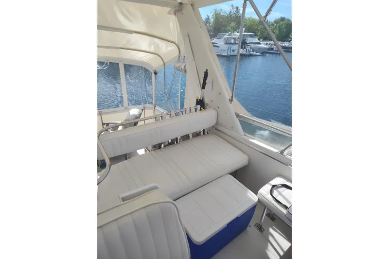 Slide: The Image of 1989 Chris-Craft 372 Catalina boat interior with white seating, docked by the water. - 6