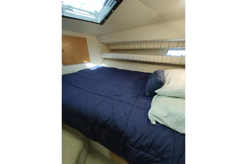 Slide: The Image of Cozy cabin interior of 1989 Chris-Craft 372 Catalina with blue bedding and natural light. - 14