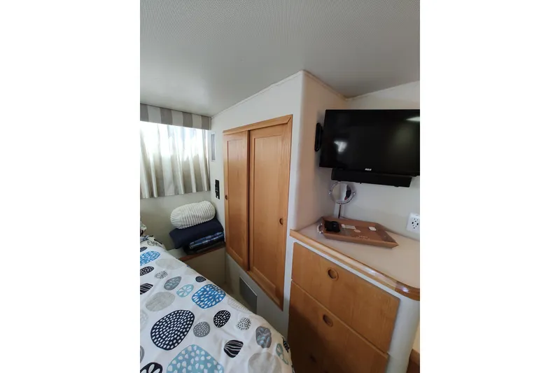 Slide: The Image of Interior of 1989 Chris-Craft 372 Catalina with TV, storage, and cozy bedding. - 20