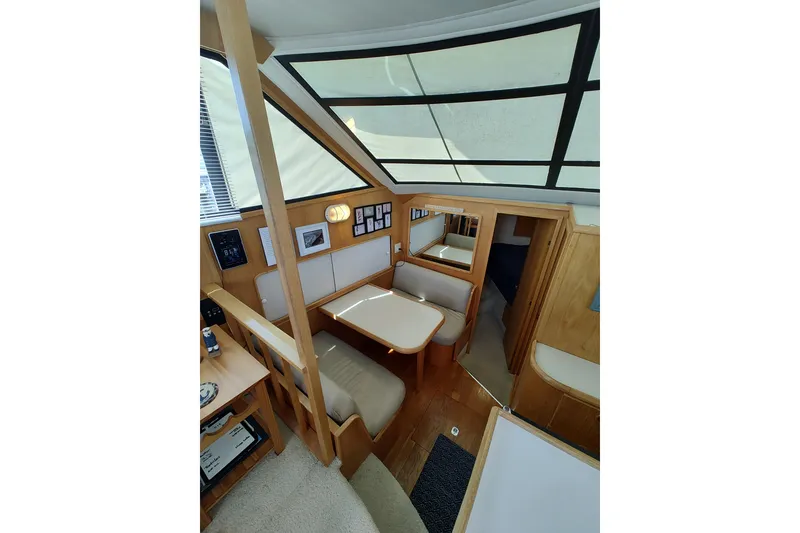 Slide: The Image of 1989 Chris-Craft 372 Catalina interior with dining area, wood accents, and large windows. - 8
