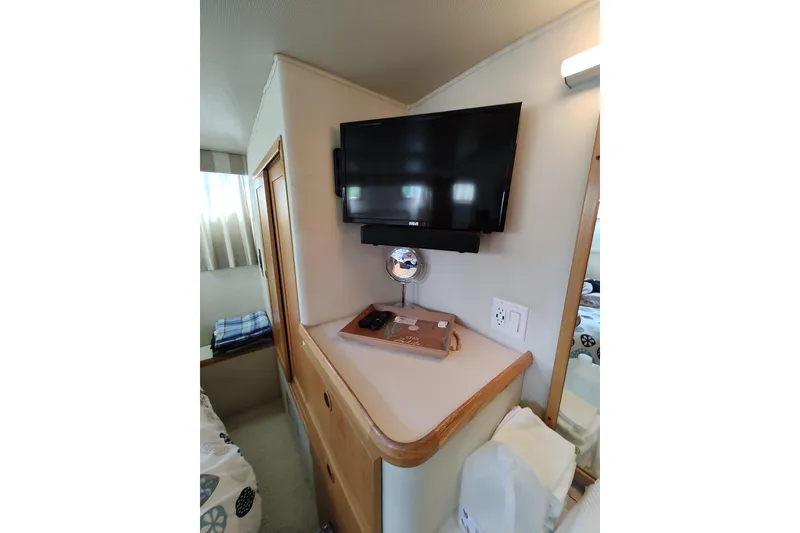 Slide: The Image of 1989 Chris-Craft 372 Catalina interior with mounted TV and cozy cabin decor. - 16