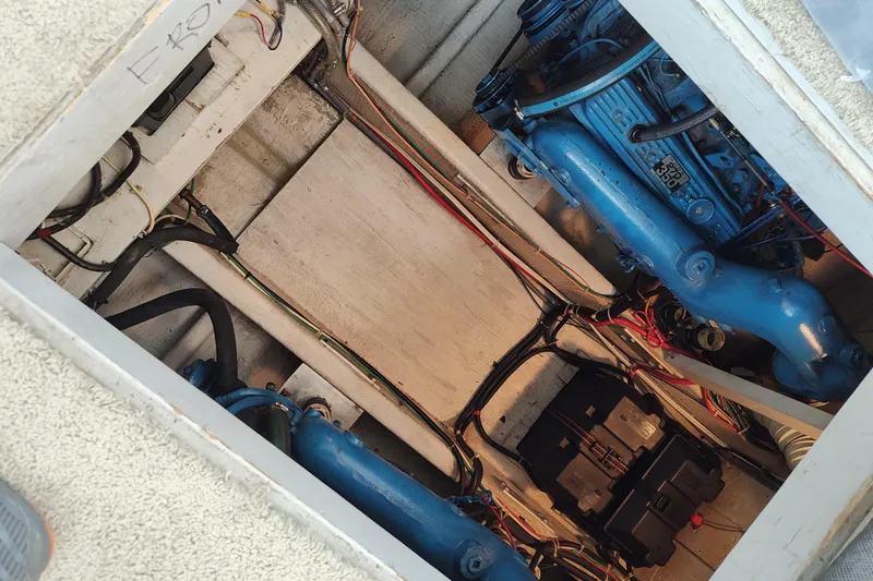 Slide: The Image of Engine compartment of 1989 Chris-Craft 372 Catalina, showcasing blue engine and wiring. - 28