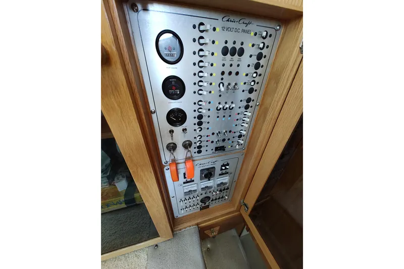 Slide: The Image of 1989 Chris-Craft 372 Catalina electrical panel with gauges and switches in wooden cabinet. - 29
