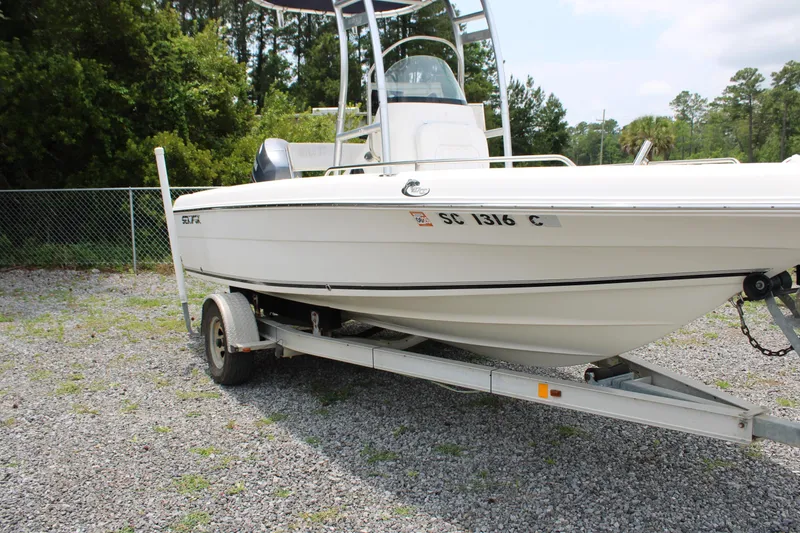 Slide: The Image of 2012 Sea Fox 187 Center Console boat on trailer, parked on gravel near trees. - 2