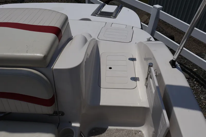 Slide: The Image of 2008 Starcraft 2000 IO Limited boat interior with white and red seating, storage compartments. - 16
