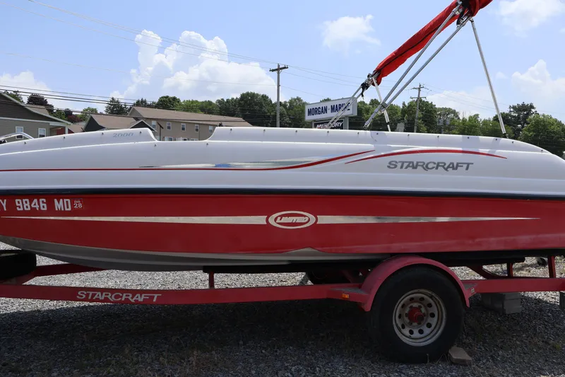 Slide: The Image of 2008 Starcraft 2000 IO Limited boat on trailer, red and white design, parked outdoors. - 40