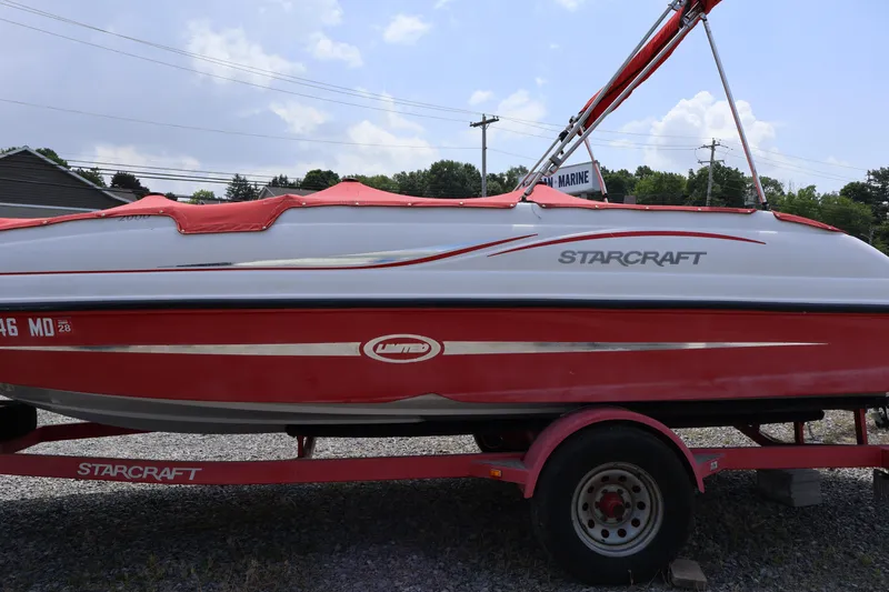 Slide: The Image of Red and white 2008 Starcraft 2000 IO Limited boat on trailer, parked outdoors. - 1