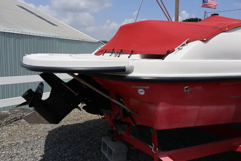 Slide: The Image of 2008 Starcraft 2000 IO Limited boat with red cover, docked outdoors. - 12