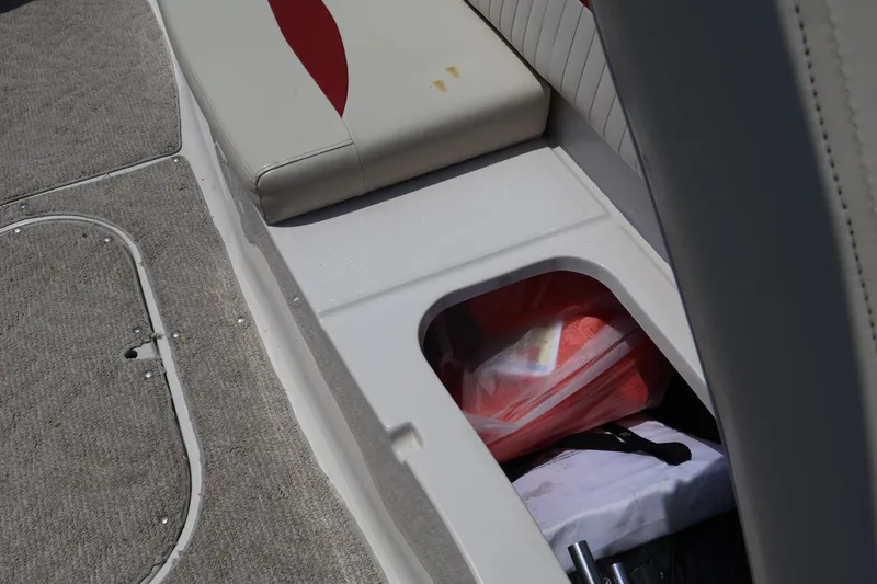 Slide: The Image of 2008 Starcraft 2000 IO Limited boat interior storage compartment with red and white items. - 45