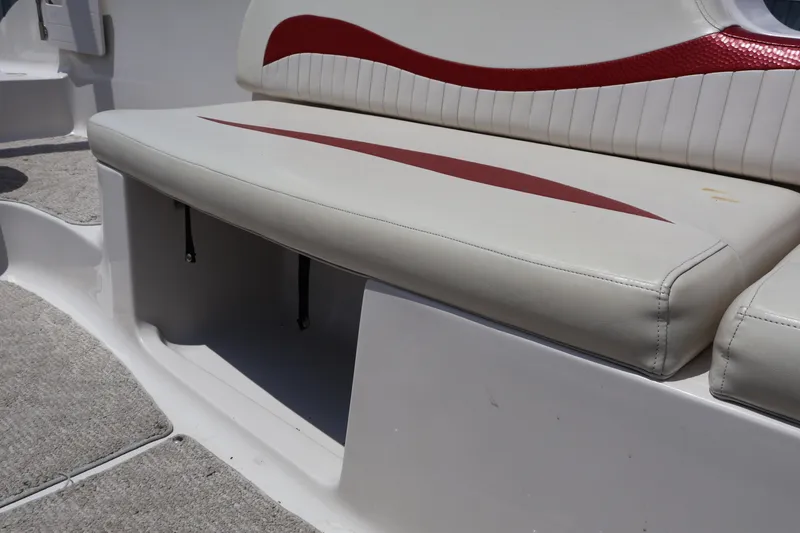Slide: The Image of 2008 Starcraft 2000 IO Limited boat seat with red accents and storage compartment. - 34