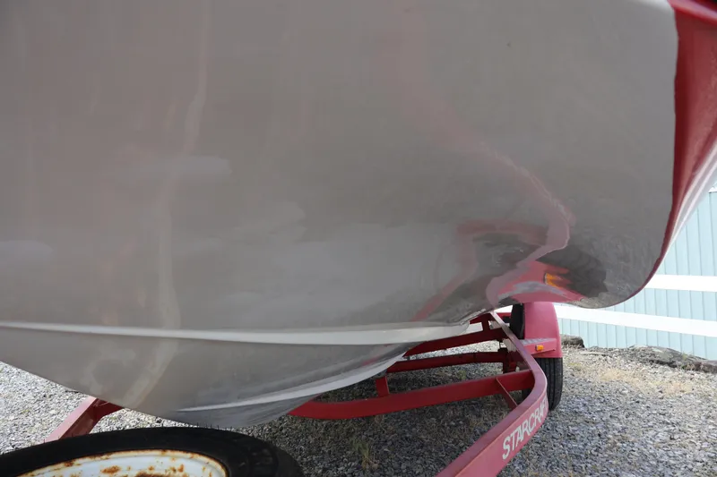 Slide: The Image of 2008 Starcraft 2000 IO Limited boat on red trailer, close-up view. - 6