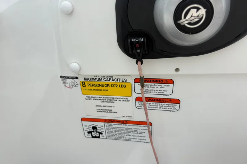 Slide: The Image of 2018 Tahoe 500 TF boat capacity label, warning signs, and ignition switch. - 11