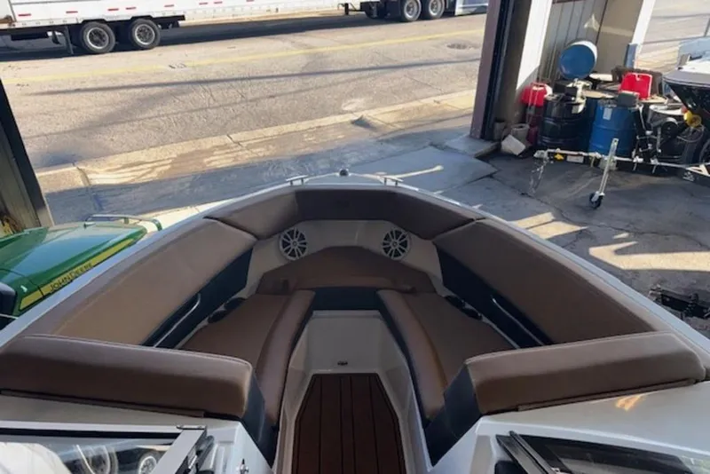 Slide: The Image of 2026 Cobalt CS22 boat interior with brown seating, parked in a garage. - 5