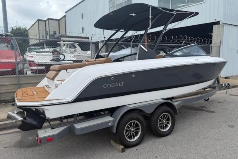 Slide: The Image of 2026 Cobalt CS22 boat on trailer, parked near industrial buildings. - 6
