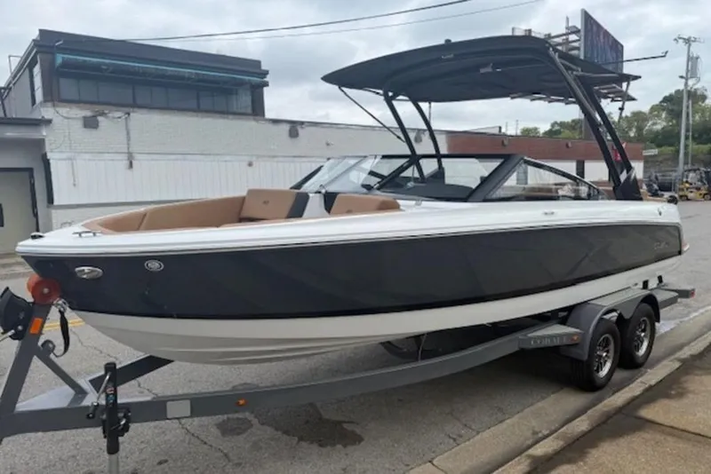 The Image of 2026 Cobalt CS22 boat on trailer, sleek design, parked on urban street. - 1