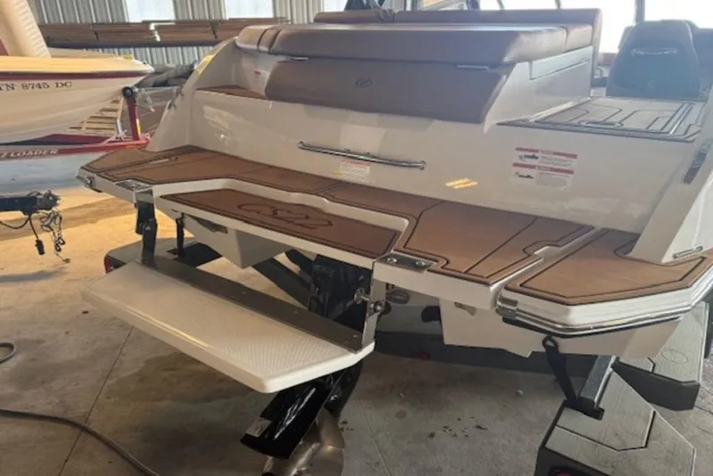 Slide: The Image of 2026 Cobalt CS22 boat with teak swim platform in a garage setting. - 8