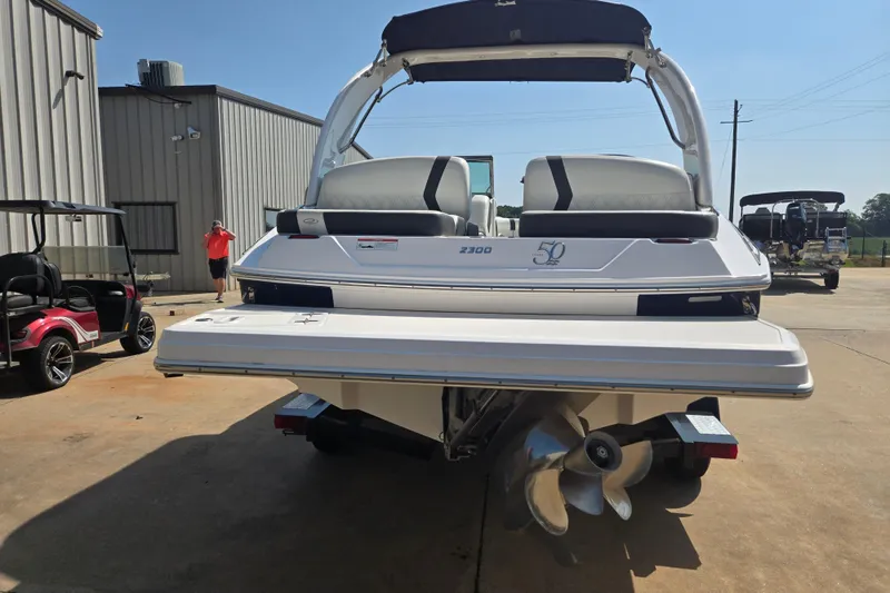 Slide: The Image of 2020 Regal 2300 Bowrider boat, rear view, parked outdoors near buildings. - 22
