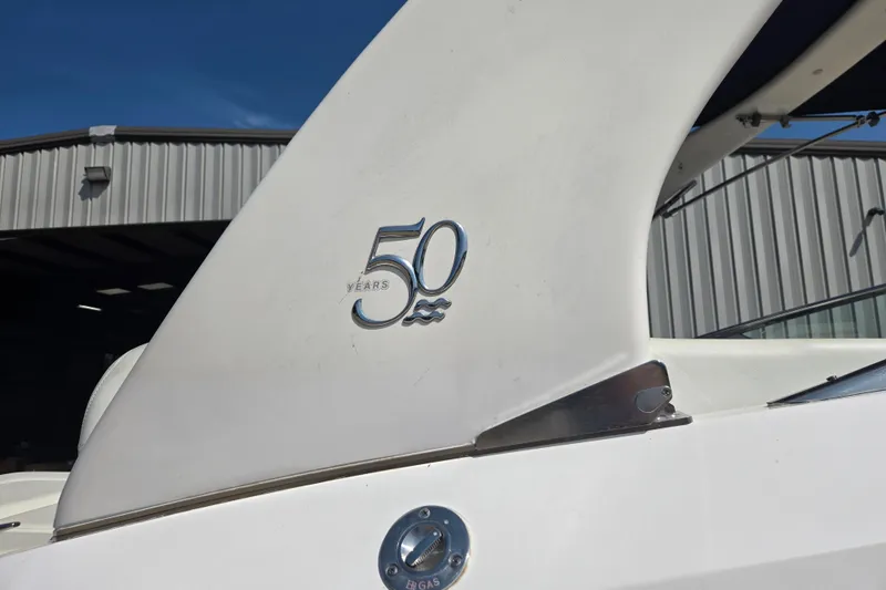 Slide: The Image of 2020 Regal 2300 Bowrider boat with "50 Years" emblem, parked near a metal building. - 24