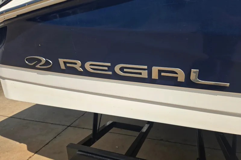 Slide: The Image of 2020 Regal 2300 Bowrider boat logo on blue and white hull. - 25
