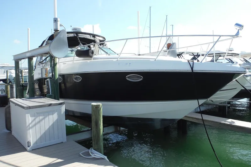 Slide: The Image of 2005 Chaparral Signature 350 boat docked at marina, featuring sleek black and white design. - 3