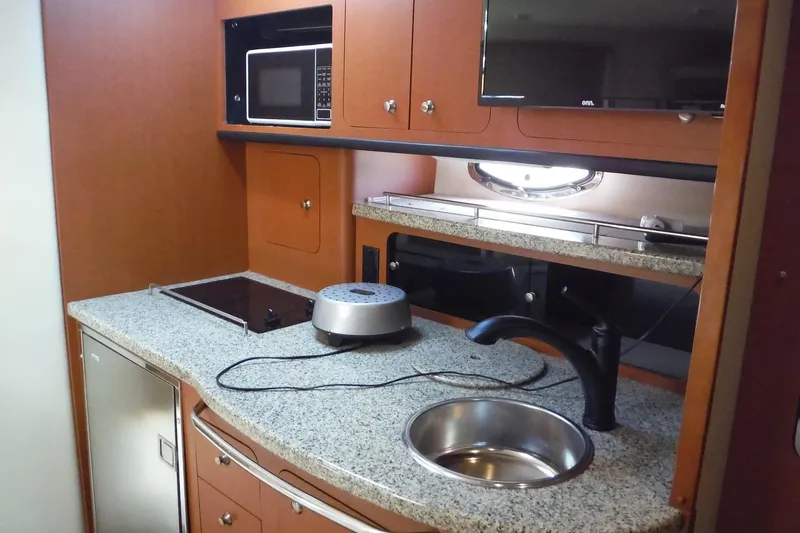 Slide: The Image of 2005 Chaparral Signature 350 yacht kitchen with granite countertops, sink, and microwave. - 19