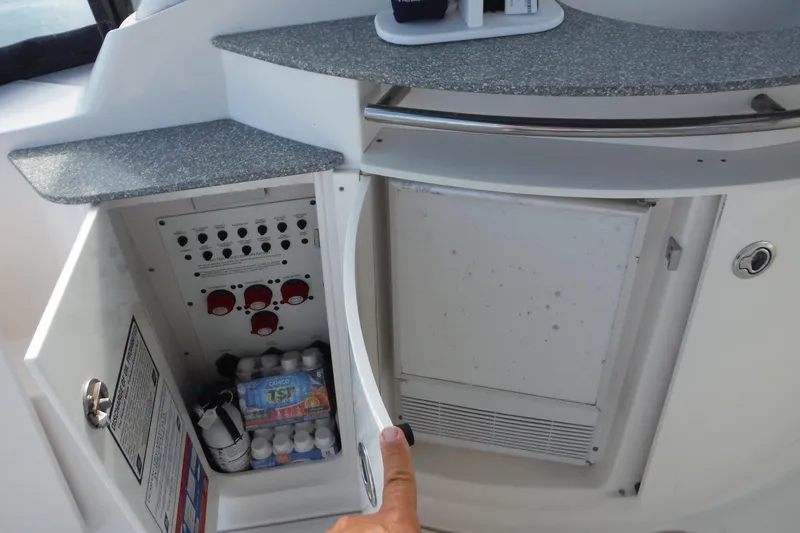 Slide: The Image of 2005 Chaparral Signature 350 yacht interior with open cabinet showing control panel and storage. - 13