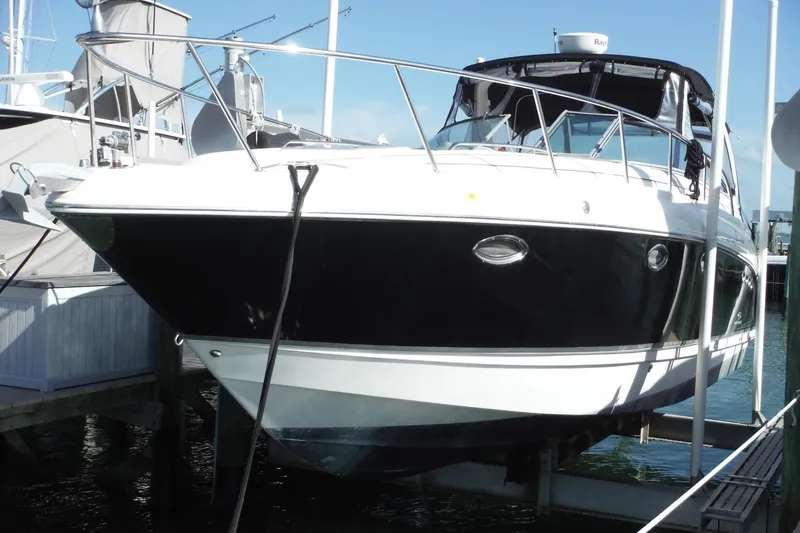 The Image of 2005 Chaparral Signature 350 boat docked at marina, featuring sleek black and white design. - 0