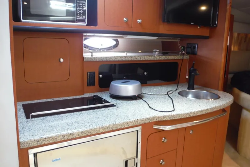 Slide: The Image of 2005 Chaparral Signature 350 yacht kitchen with microwave, stove, and sink. - 27