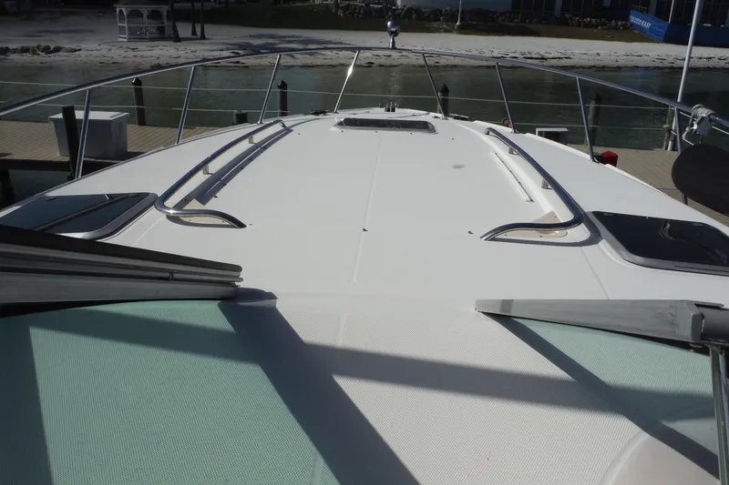 Slide: The Image of 2005 Chaparral Signature 350 yacht deck with railing, docked by a sandy shore. - 9