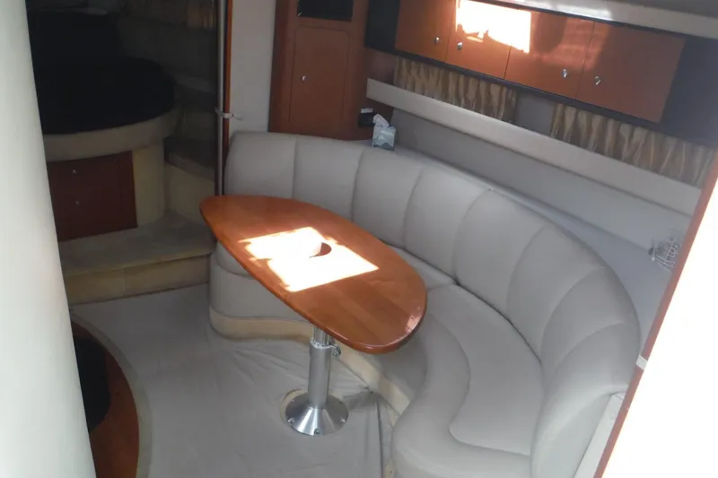Slide: The Image of Interior of 2005 Chaparral Signature 350 yacht with curved seating and wooden table. - 16