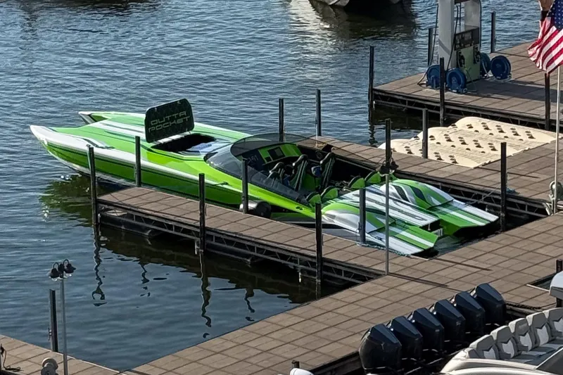 Slide: The Image of Green Skater 388 speedboat docked, 2025 model, with sleek design and vibrant stripes. - 15