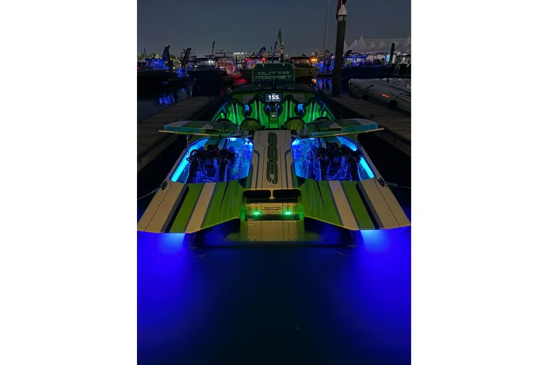 Slide: The Image of 2025 Skater 388 boat with vibrant blue and green lights at night dock. - 8