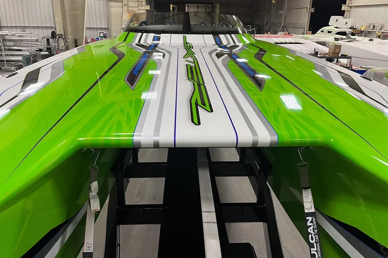 Slide: The Image of 2025 Skater 388 boat with vibrant green and white design in a workshop setting. - 14