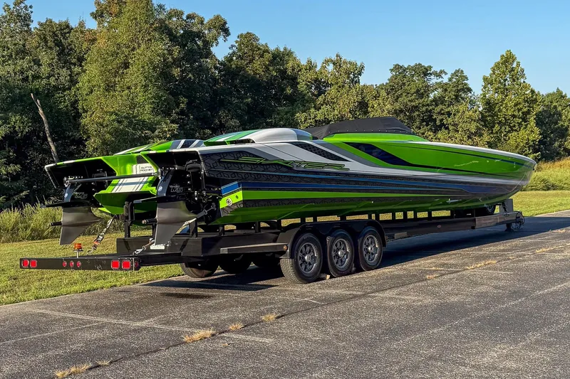 Slide: The Image of 2025 Skater 388 powerboat in vibrant green on a trailer, set against a lush, wooded backdrop. - 17