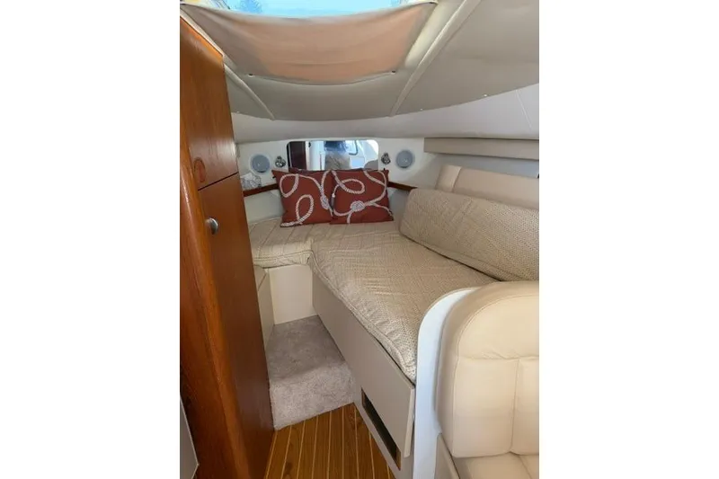 Slide: The Image of Cozy cabin interior of a 2002 Tiara 29 boat with beige seating and decorative pillows. - 14