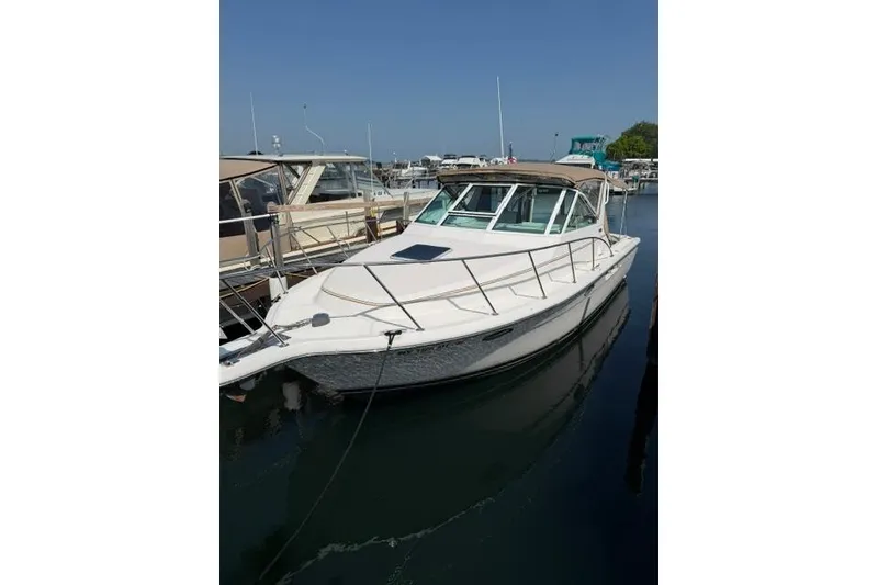 Slide: The Image of 2002 Tiara 29 boat docked at marina under clear blue sky. - 4