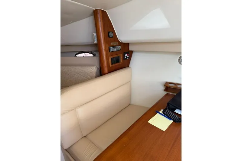 Slide: The Image of Interior of a 2002 Tiara 29 boat with beige seating and wooden accents. - 13