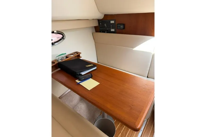 Slide: The Image of Interior of a 2002 Tiara 29 boat with a wooden table and seating area. - 12