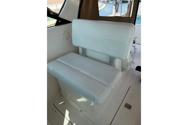 Slide: The Image of White leather seat on a 2002 Tiara 29 boat, near a window with water view. - 6