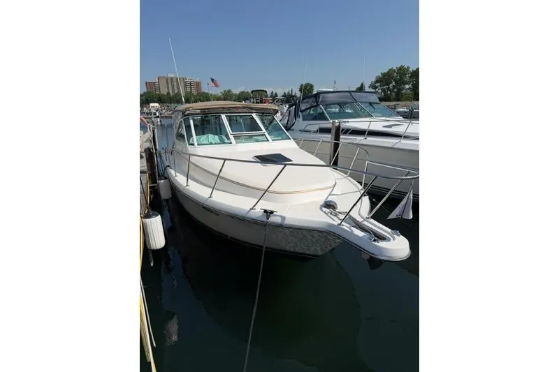 Slide: The Image of 2002 Tiara 29 boat docked in a marina under clear blue skies. - 3