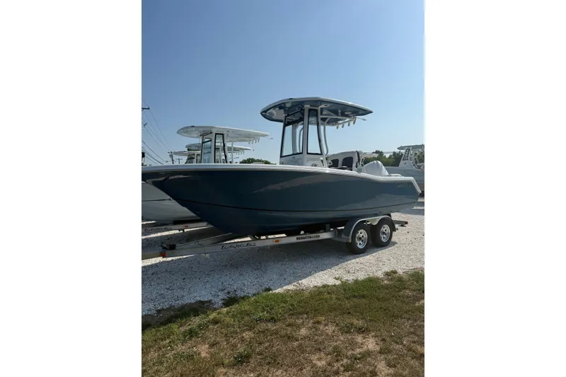 Slide: The Image of 2027 Tidewater 220 LXF boat on trailer, parked outdoors under clear sky. - 2