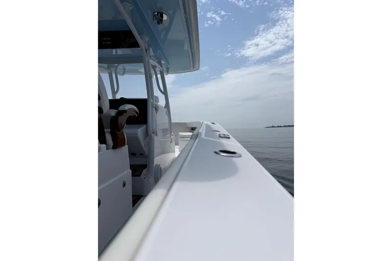 Slide: The Image of 2021 Jupiter 38 HFS boat on calm water under a partly cloudy sky. - 8