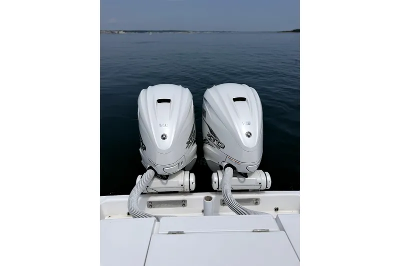 Slide: The Image of Twin outboard engines on a 2021 Jupiter 38 HFS boat, overlooking calm waters. - 10