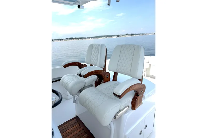 Slide: The Image of Luxury seating on 2021 Jupiter 38 HFS boat, featuring elegant white upholstery and wooden accents. - 6