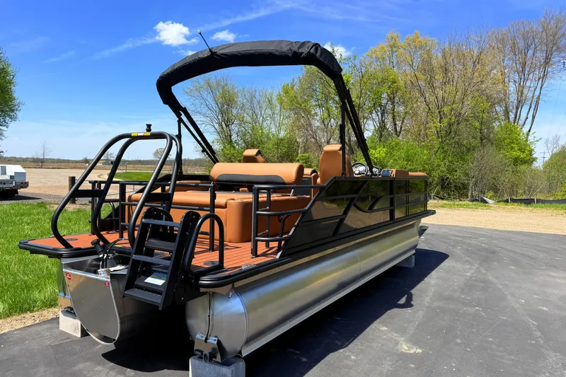 Slide: The Image of 2026 Bentley Pontoons Legacy 223 Swingback on pavement, surrounded by trees and blue sky. - 4