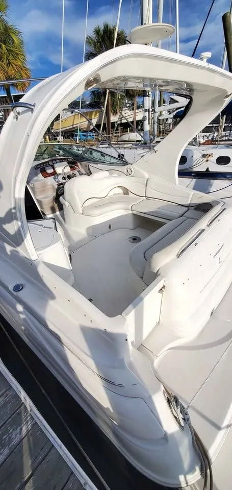 Slide: The Image of The image shows a 2002 Wellcraft 3300 Martinique docked at a marina. - 3